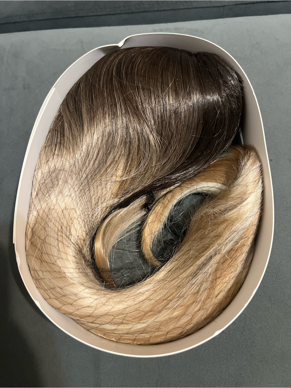 hairpiece featuring a dark brown root that transitions smoothly into a bright bl
